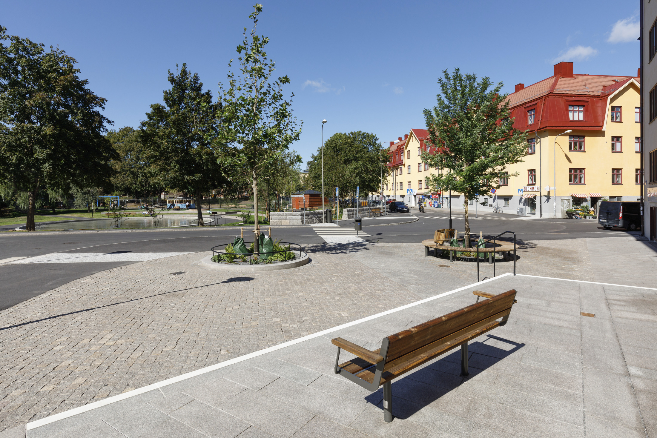 Utsikt över plaskdamm och lekplats i Svandammsparken